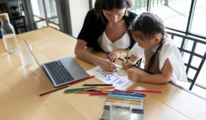 Mãe ajudando a filha com reforço escolar em casa